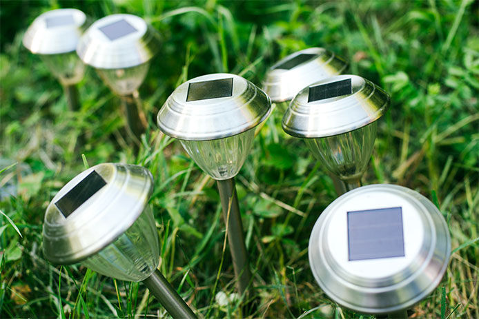 a cluster of solar path lights sticking out of a grassy area. 