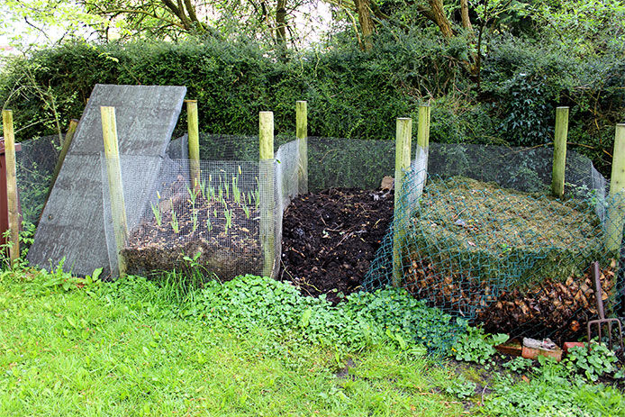 Using mesh and wooden posts for backyard compost piles