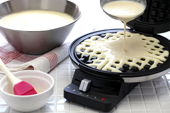 Pouring waffle batter on onto the waffle maker