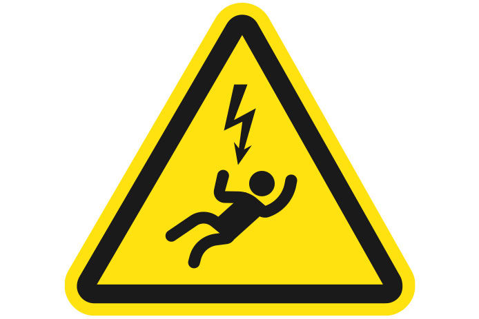 A yellow caution sign indicating the danger of electric shock. The sign shows the figure of a person in black on their back with a jagged lightning symbol above them.