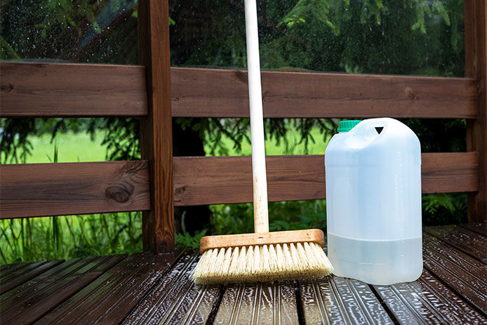 A deck scrubber and a jug of cleaning fluid