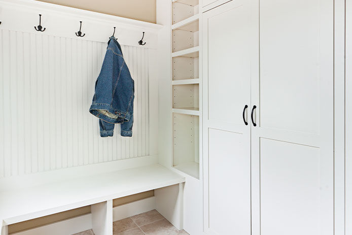 A family style of mudroom with hooks to hang up jackets and a closet to store backpacks and other items used to go outside