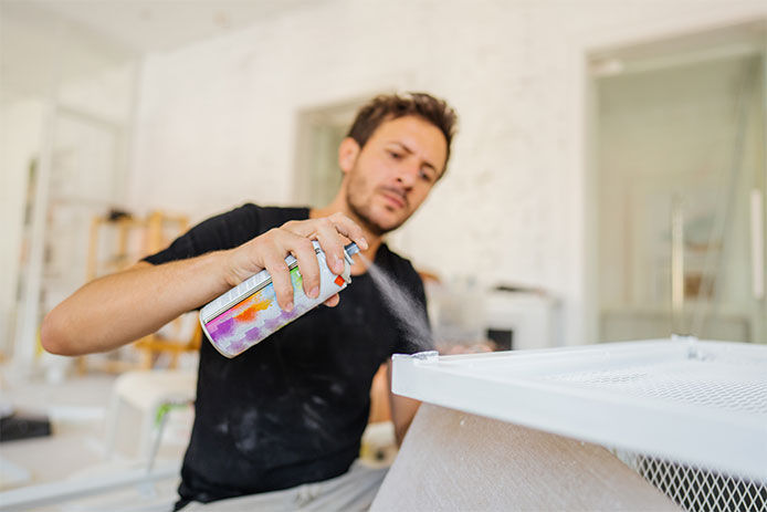 Man spray paiting inside