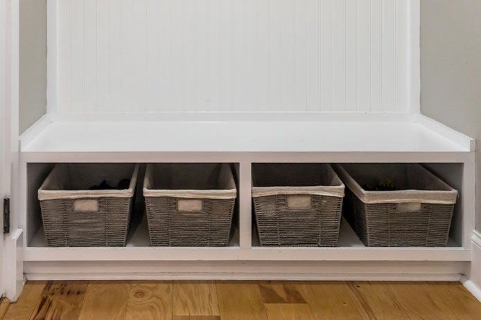 lower storage area in a mudroom with woven baskets used for holding smaller items 