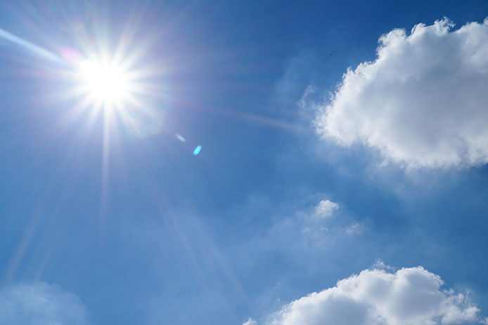 Sunny blue sky with white fluffy clouds