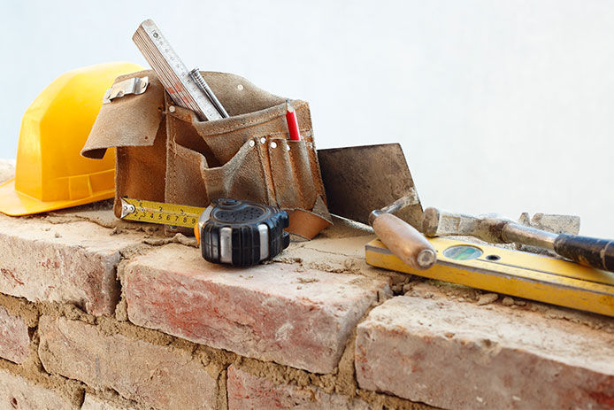Various tools on brick wall.