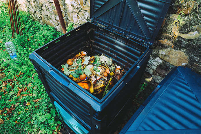 Showing a trash can now being used as a compost bin