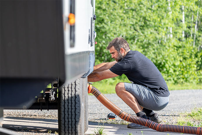 A man cleaning out the wastewater of an RV