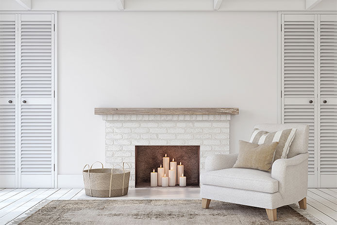 A white modern living room with a white mantle fireplace 