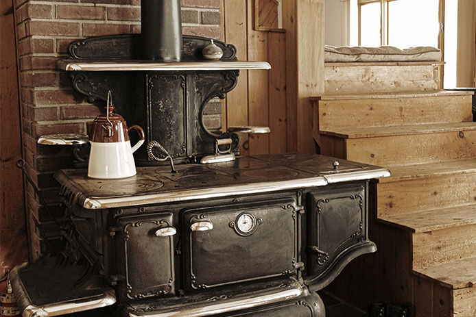 A black wood stove located next to a set of stairs