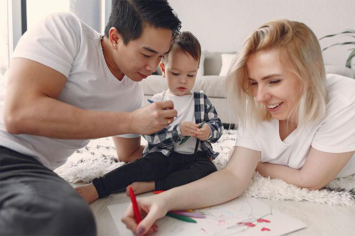 Mom and dad coloring with their baby