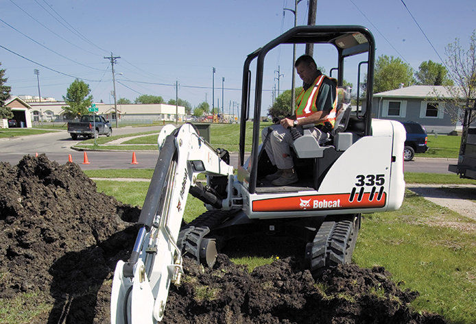 A bobcat digging in a yard