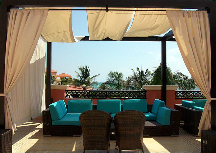 A patio with a privacy gazebo and curtains