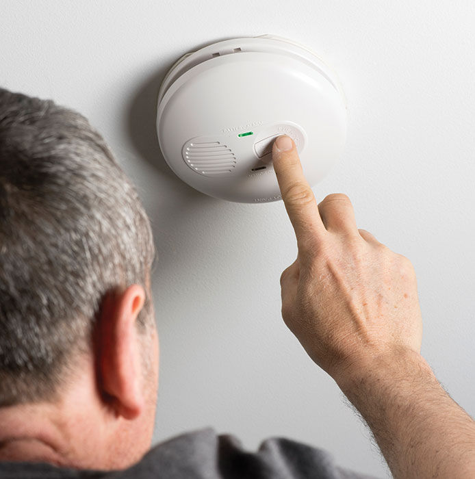 A man testing a smoke detector