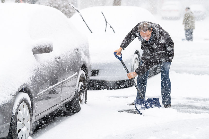 Man shoveling snow from driveway