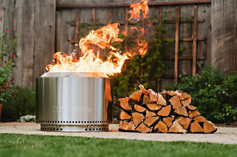 Solo Stove Smokeless Fire Pit with a stack of wood next to it 