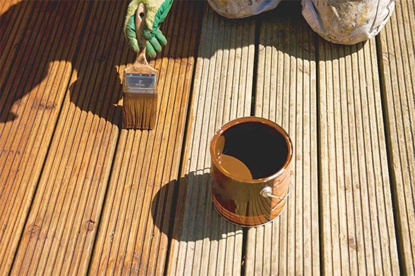 Paint brush applying stain