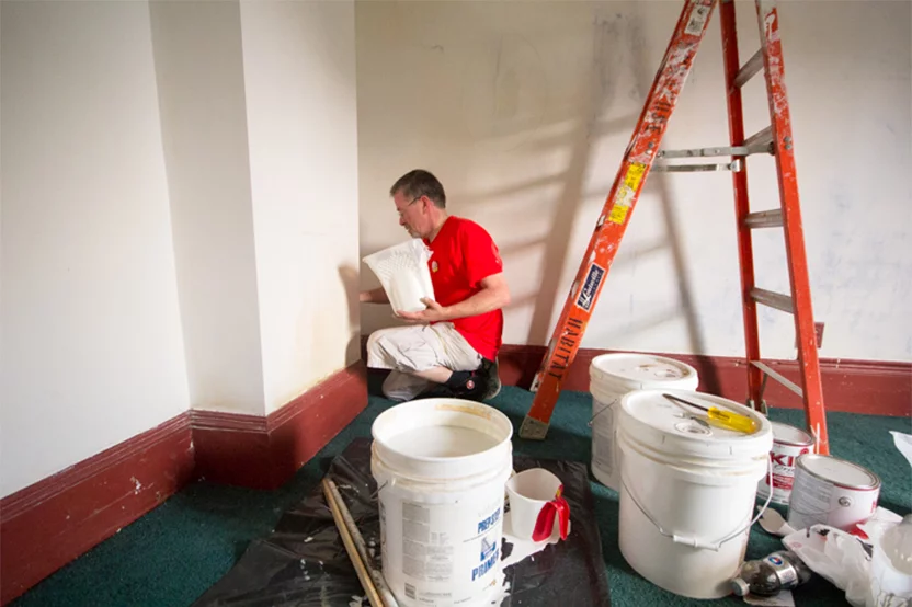 man painting a room in a home