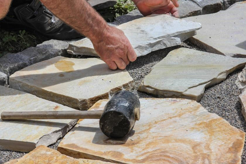 Laying flagstone down on pea gravel to make a walkway