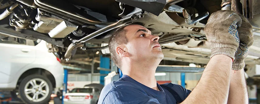 Auto Mechanic Working on a Car