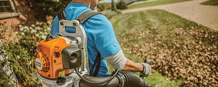 Man Blower Leaves With a STIHL Leaf Blower