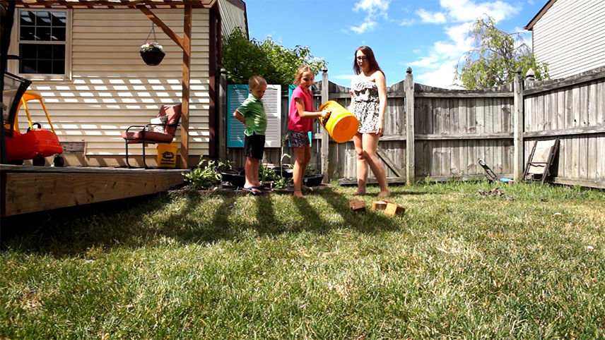 Kids playing yardzee in a backyard