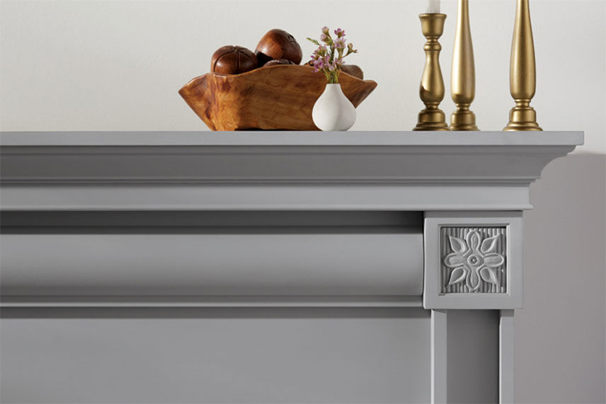 Gray chalk paint mantel with golden candlesticks on top