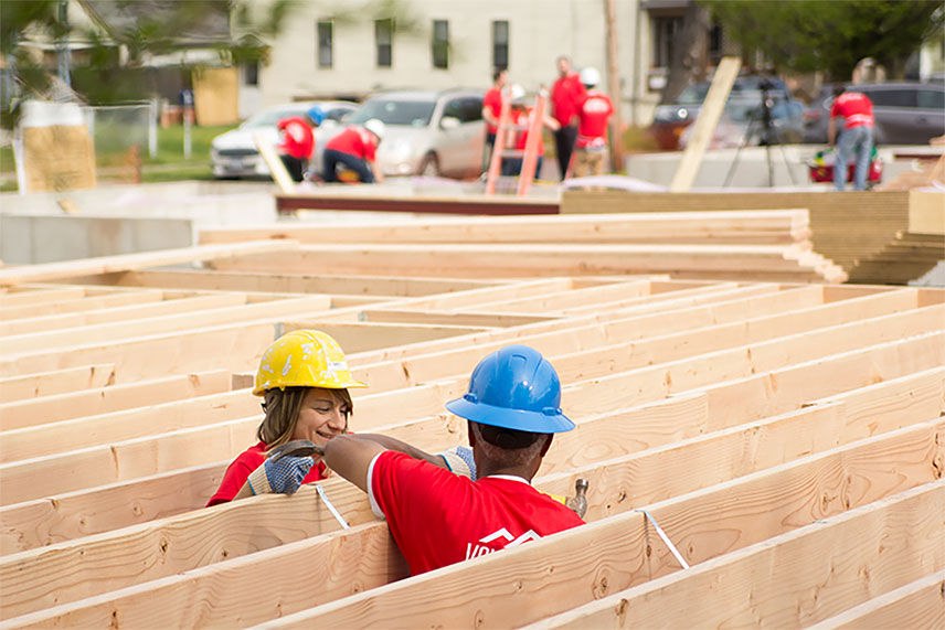 Two Value crew members talkin and working on the framing of the house