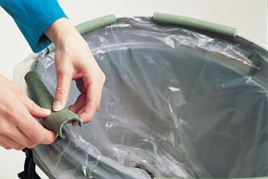 garden hose wrapped around the top of a trash can