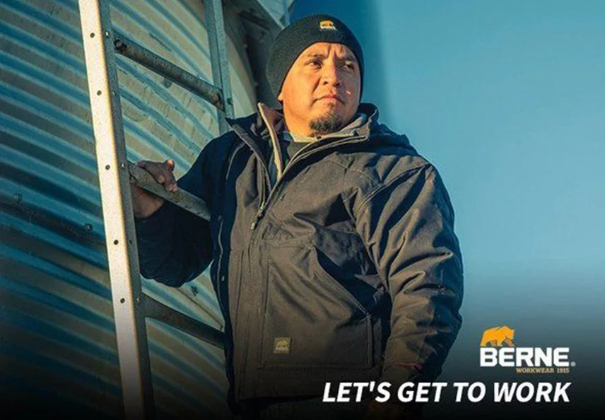 Man Wearing Berne Jacket and Hat on a Ladder