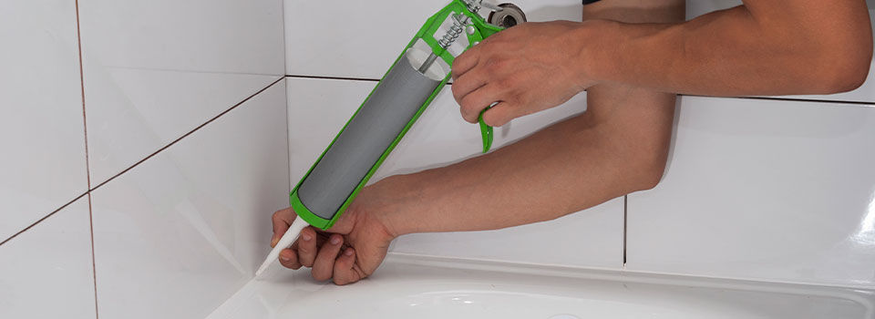 plumber apply silicone sealant to the joint bathtubs and ceramic tile