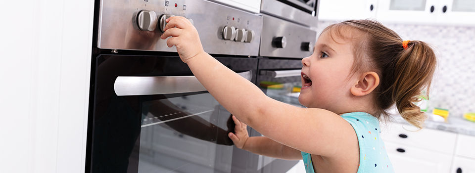 A child turning oven knobs