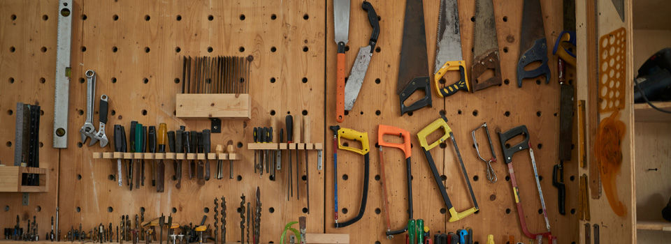 hand saws on the wall of a garage work area