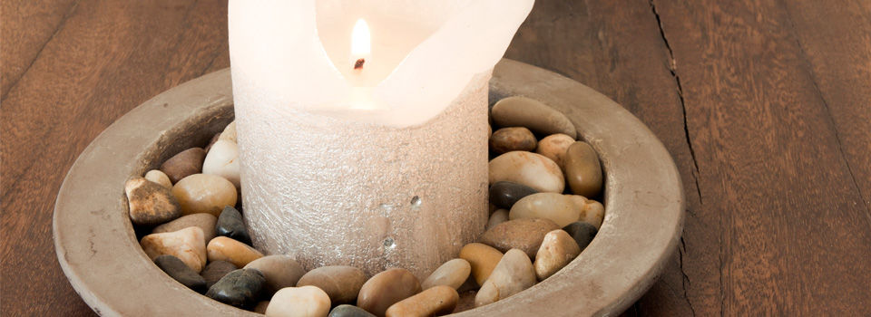 Lit candle with rocks around it