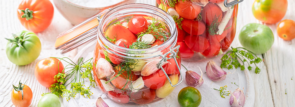 Homemade pickled tomatoes with garlic, horseradish and dill. Pickling tomatoes at home.