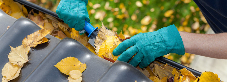 a person wearing gloves and cleaning gutters