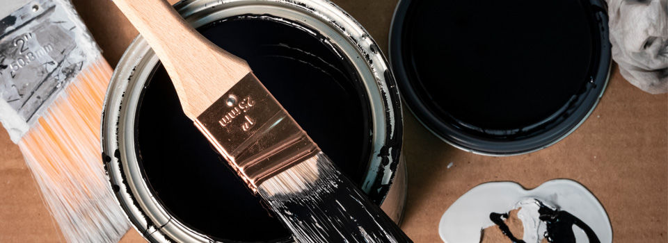 Open paint can with paint brush