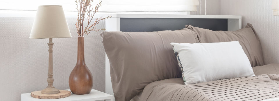 brightly lit bedroom with a bed and nightstand table