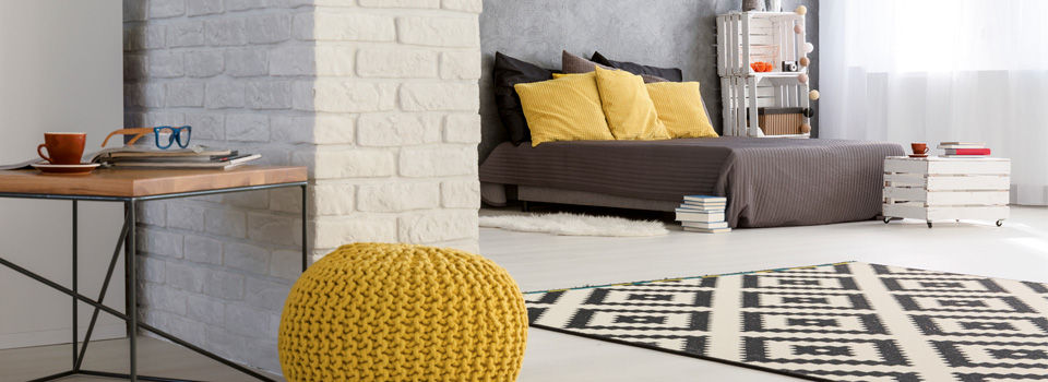 White brick with grey furniture and yellow accent pillows