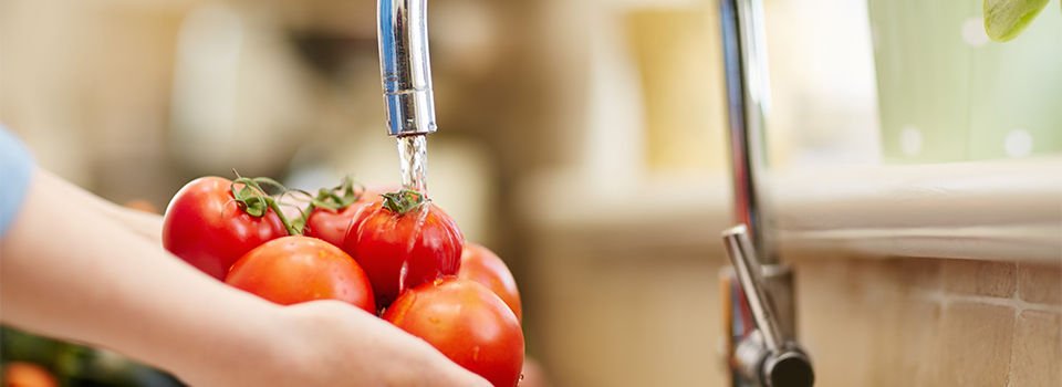 Washing tomatoes in a kitchen sink