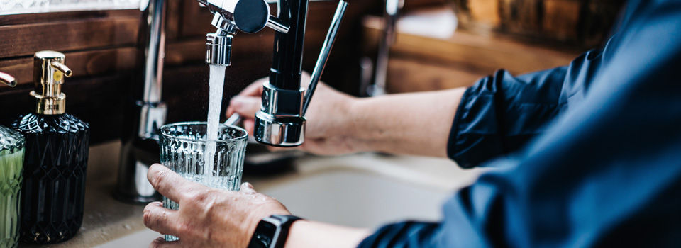 person getting water from a sink with a water filter