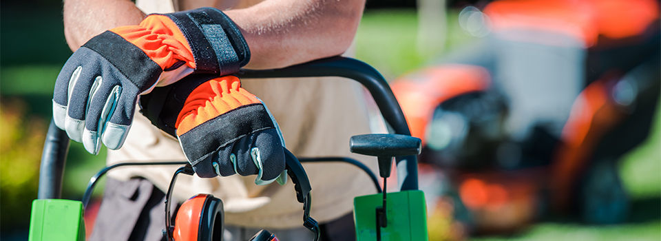 A man leaning on a lawn mower