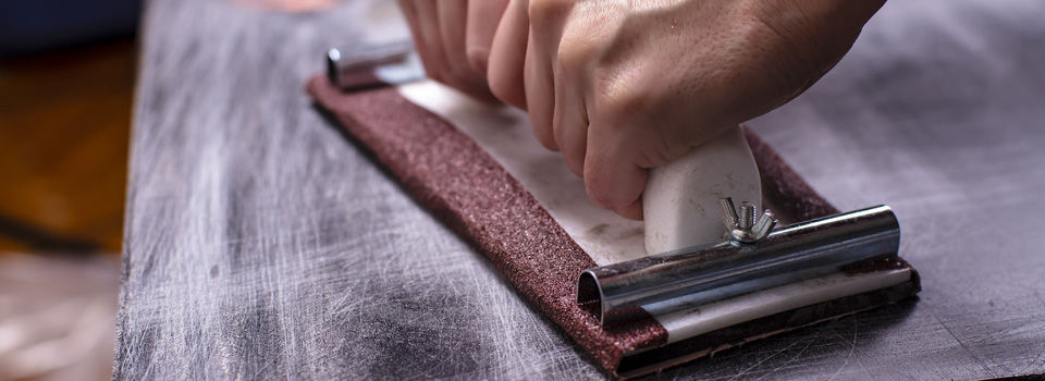 a man sanding an old wood table top