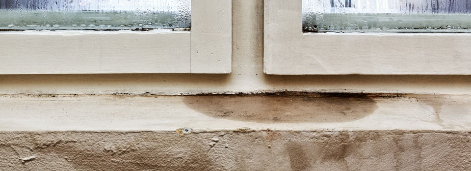 water damage on window in a basement with a leak