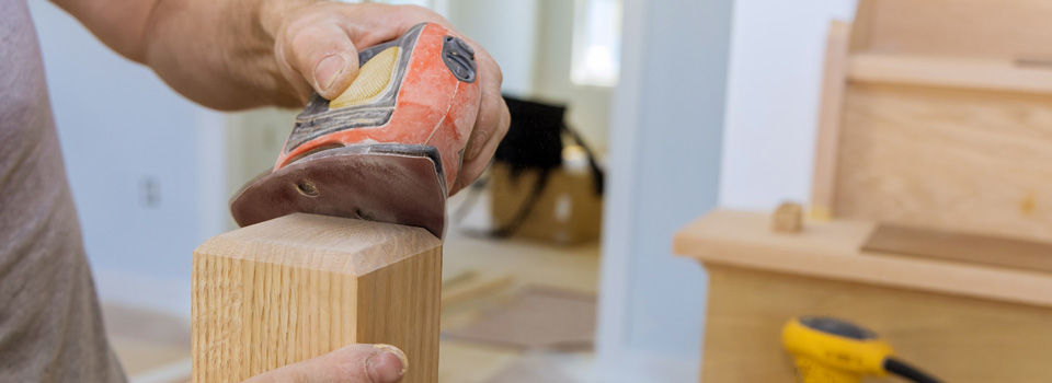 a person sanding wood with a sander and another sander on the steps behind them