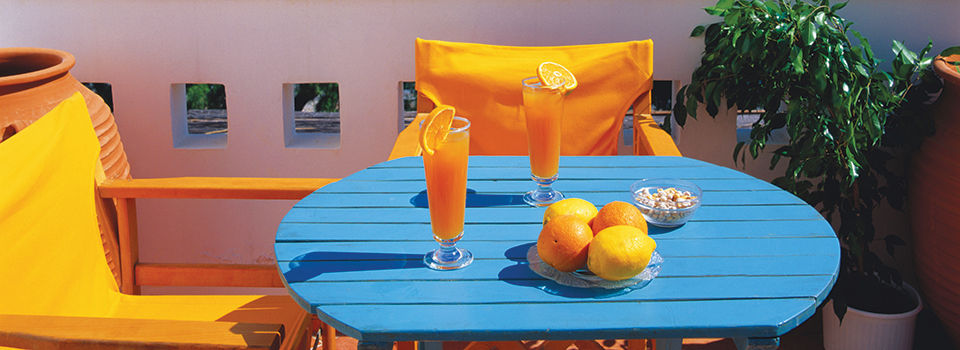 An outdoor space with a blue table and orange chairs