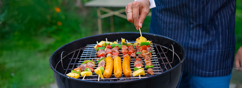 Grilling skewers and sausages on barbecue grill outdoors
