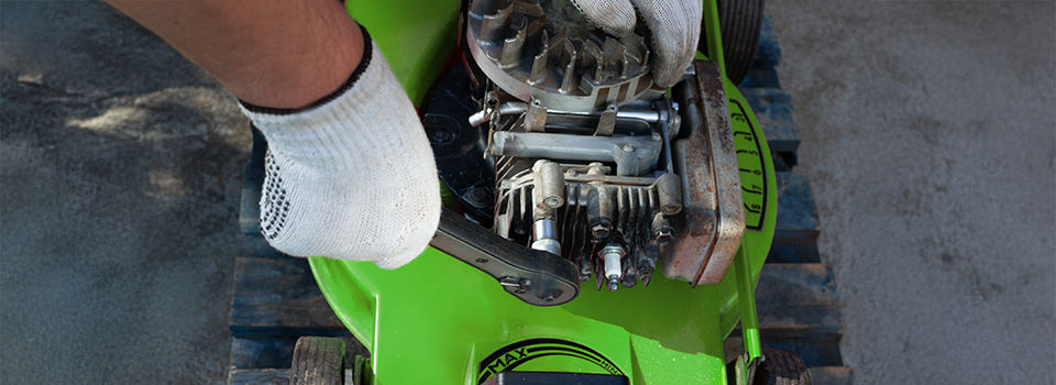 Man repairing an fix an old lawn mower.