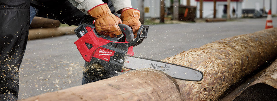 Cordless Milwaukee chainsaw cutting a tree
