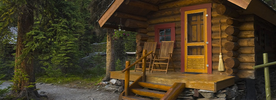 The outside of a cabin looking at the porch with two rocking chairs